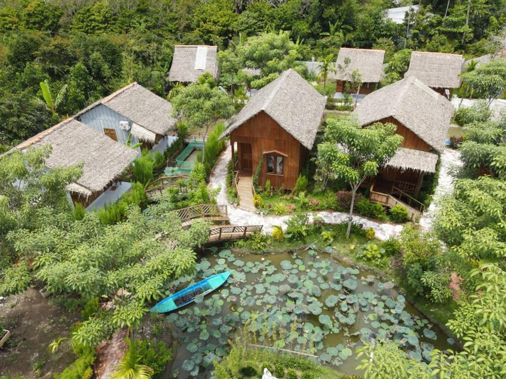 Ấp Nhơn BìnhMuong Dinh Lodge的享有带池塘和房屋的空中景致