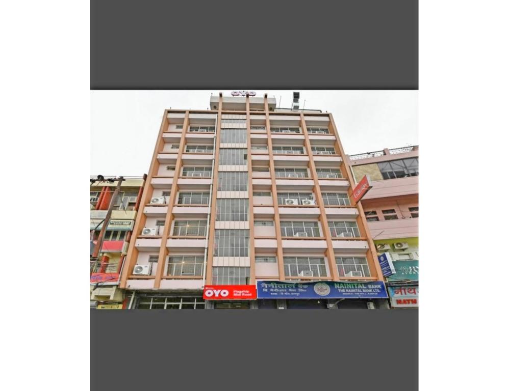 坎普尔Hotel Kanha Classic, Kanpur的一座高大的建筑,旁边有一个标志