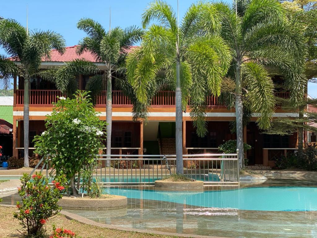 邦咯PANGKOR PURNAMA CHALET的一座棕榈树和游泳池的建筑