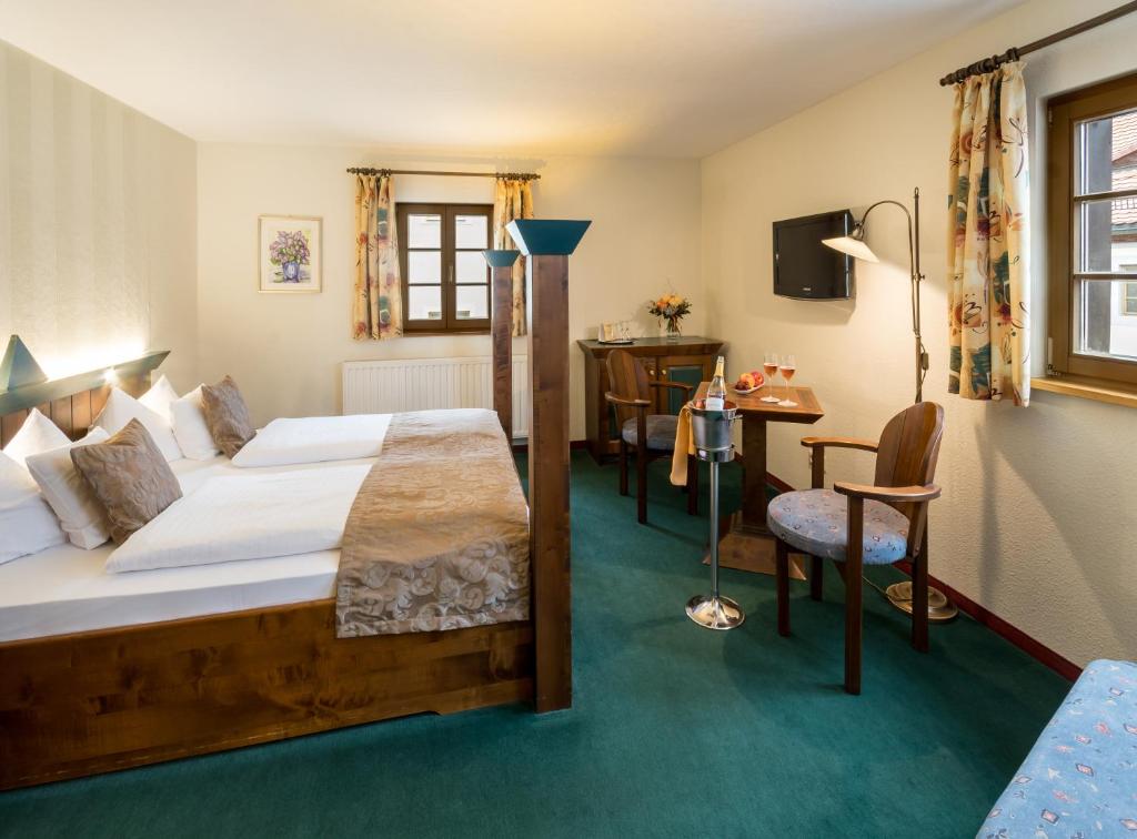 奥尔贝尔恩豪塞格胡特酒店的酒店客房配有一张床、一张桌子和一把椅子。