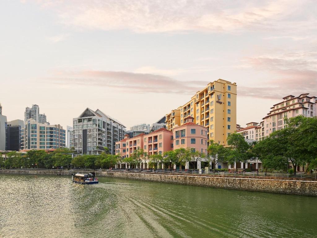 新加坡远东集团悦乐罗伯森码头公寓的城市中建有建筑物的河上的小船
