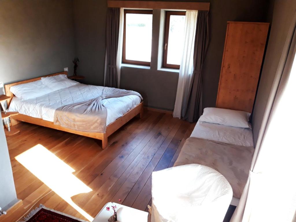 MaioloB&B EcoAntico casa in paglia的一间卧室设有两张床和窗户。