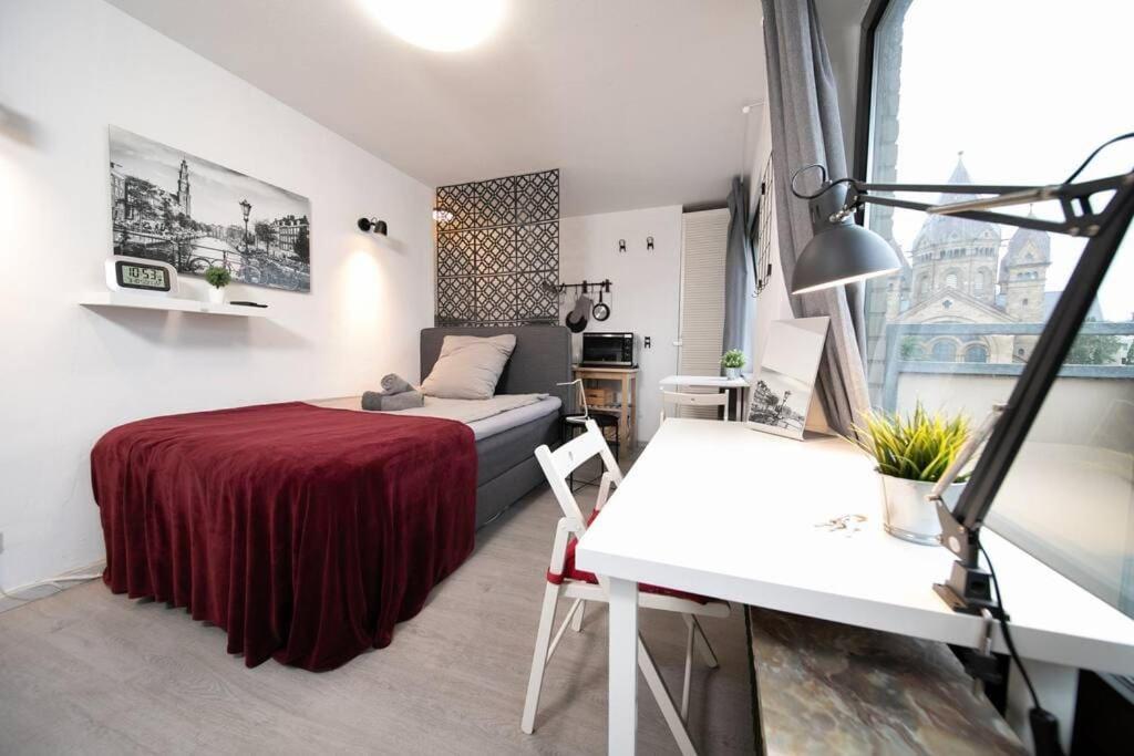 杜塞尔多夫Studio Rosso - Central - Balcony - Trade Fair的一间卧室配有一张床、一张桌子和一张书桌