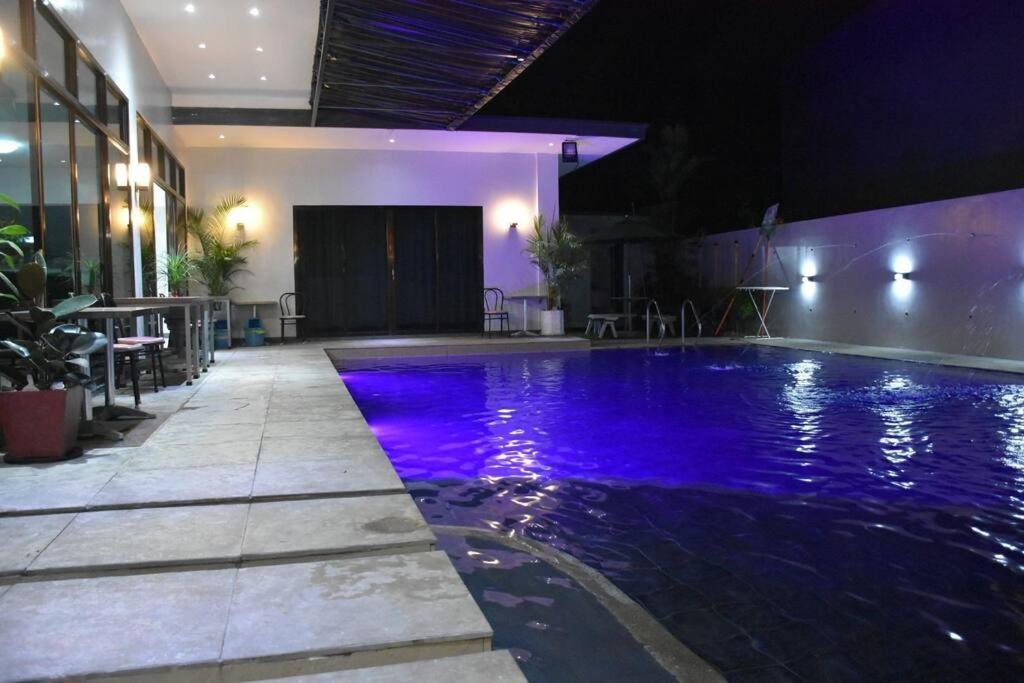 卡兰巴Lovely 2-bedroom hotspring resort的一座建筑中一座带紫色灯光的游泳池