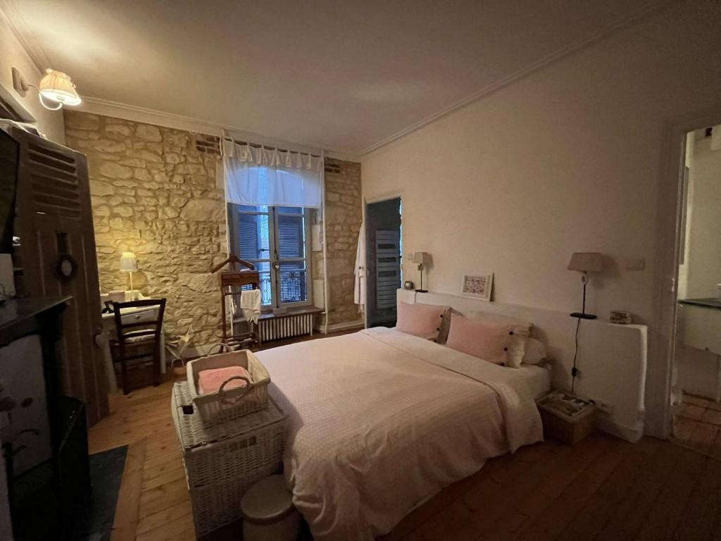 勒芒Chambres d'hôtes de charme sur LE MANS的一间卧室设有一张大床和石墙