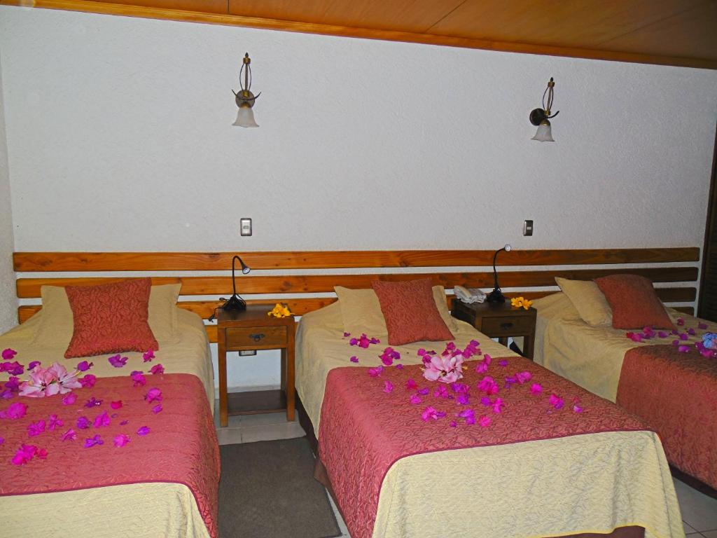 安加罗阿Hotel Puku Vai的酒店客房,配有两张带鲜花的床