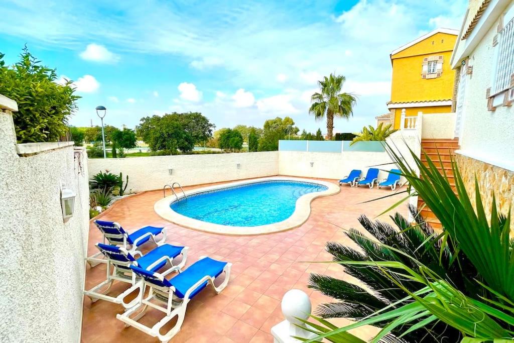 马力诺港14 VILLA relax private pool的一个带蓝色椅子的游泳池和一个泳池景