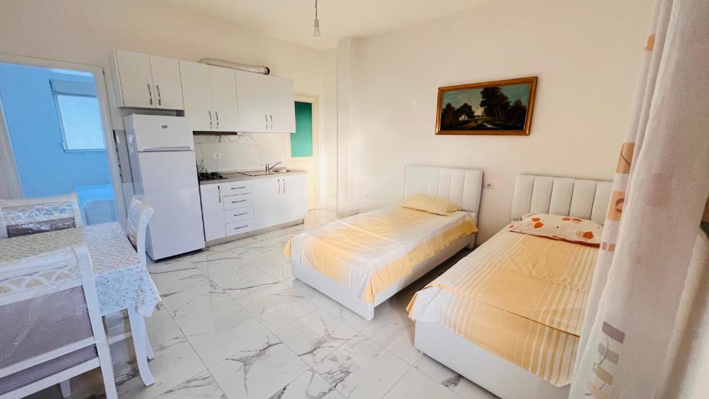 斯比勒Kleida Beach Vacation Rentals的一间带两张床的卧室和一间带冰箱的厨房