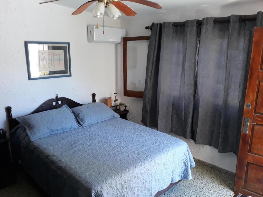 埃斯特角城Suíte的一间卧室配有一张床和吊扇