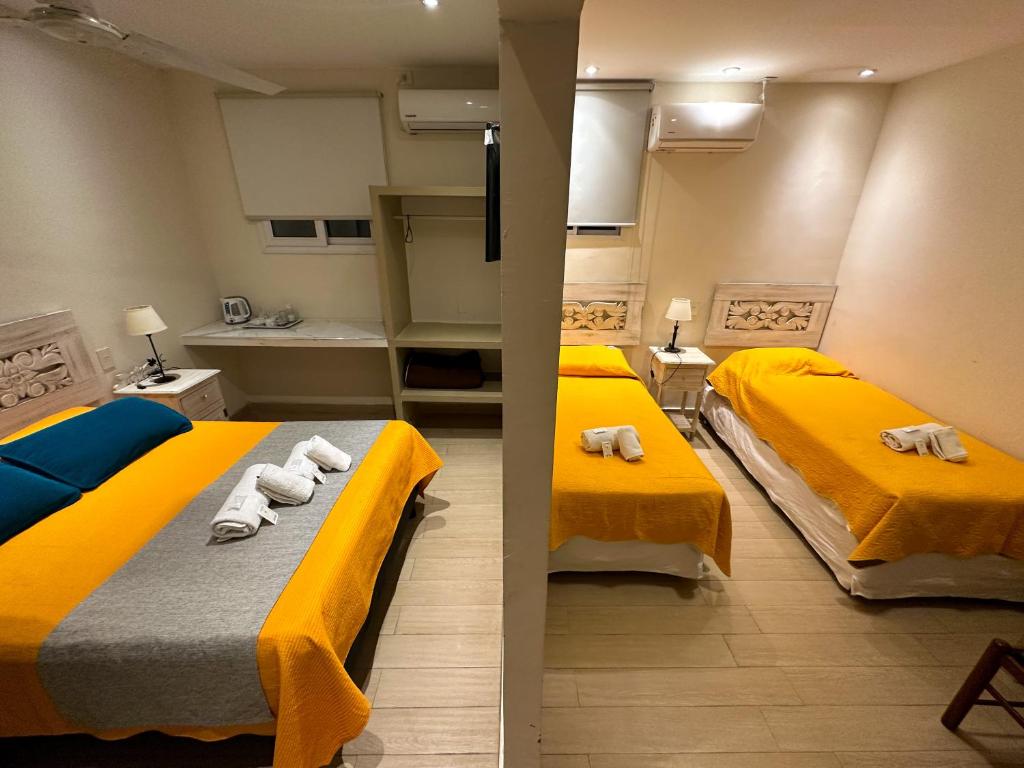 圣萨尔瓦多德朱Hotel ICONICO JUJUY Centro的小型客房配有两张黄色床铺。