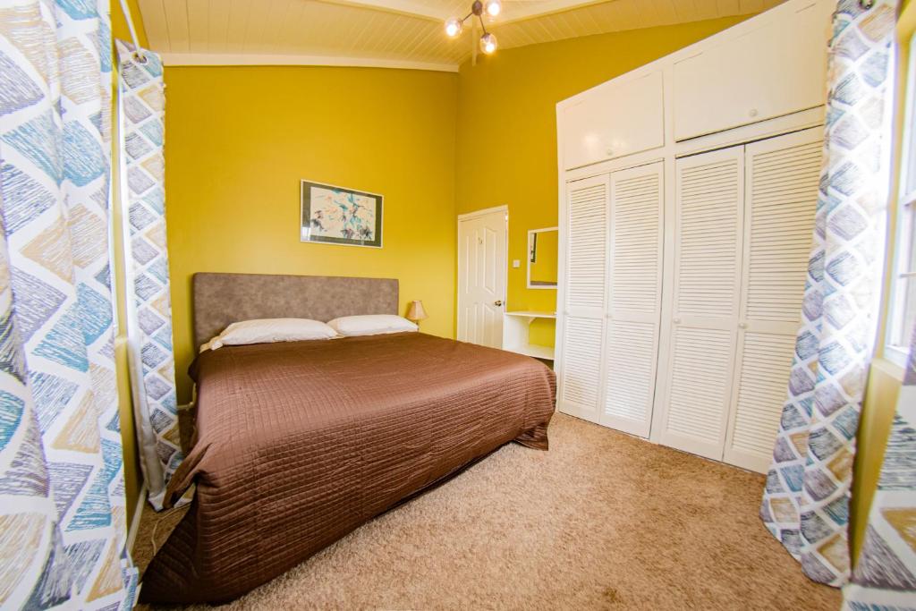 乔治敦JR Apartments的一间卧室设有一张床和黄色的墙壁