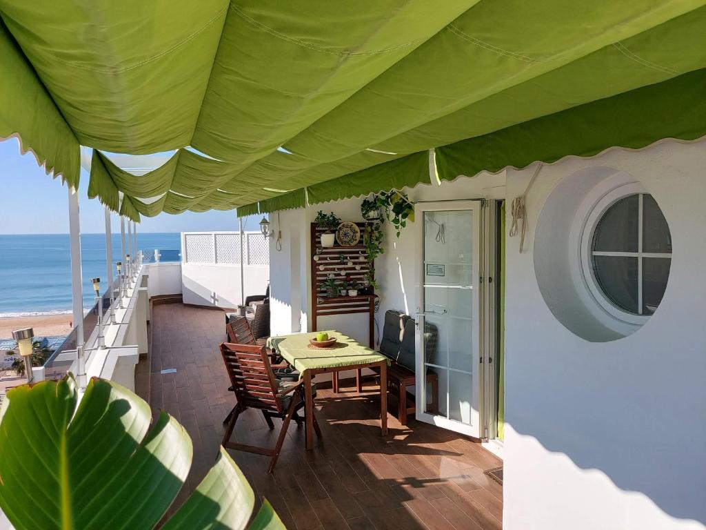 加的斯ÁTICO VICTORIA BEACH的海滩阳台的桌椅