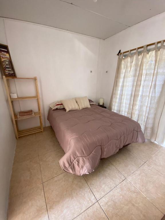 楚伊El três的一间带床的卧室,位于带窗帘的房间
