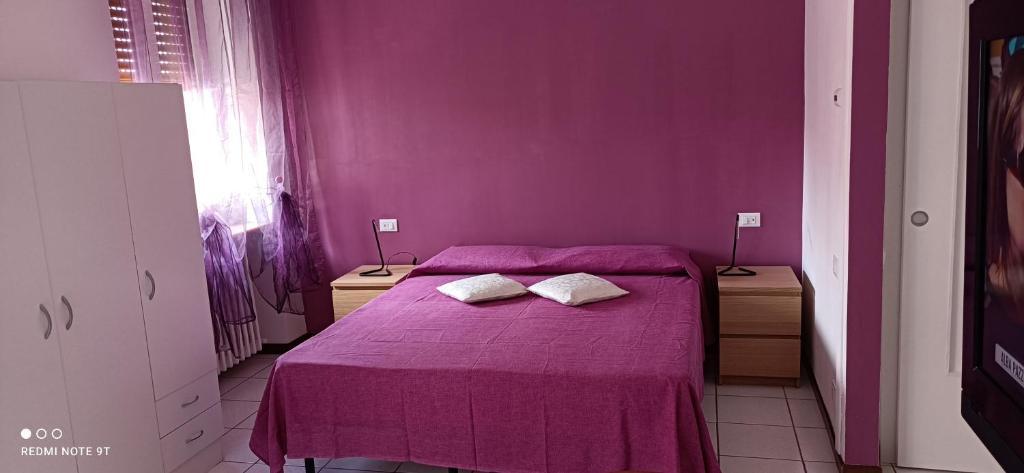 BregnanoAppartamento tra Como e Milano的紫色卧室配有一张带两个枕头的床