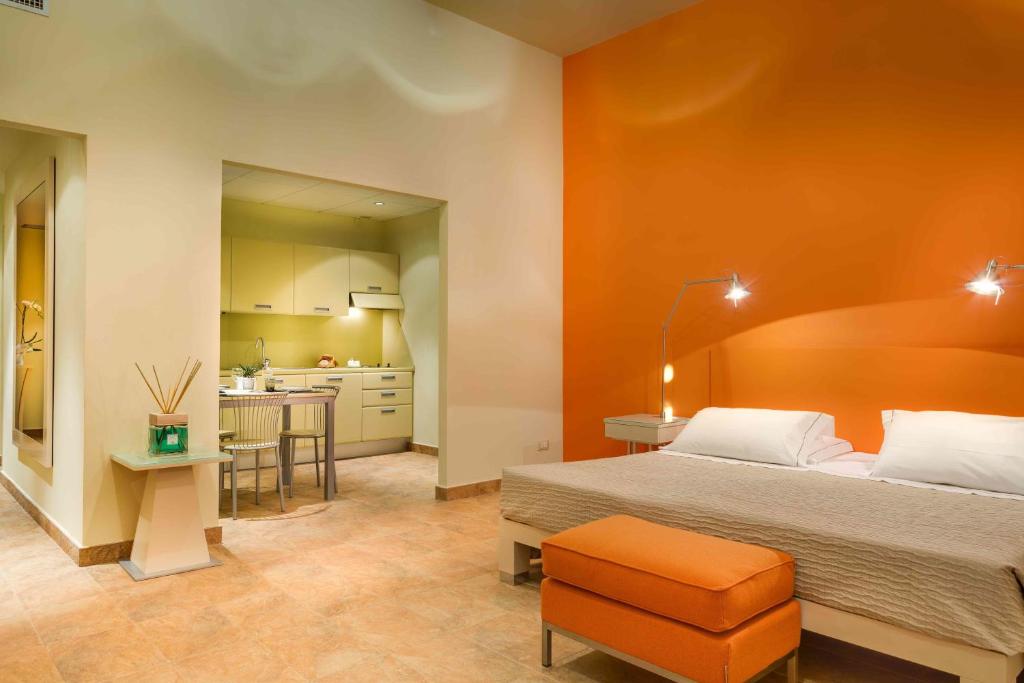佛罗伦萨Pop公寓式酒店的一间卧室设有一张床和橙色的墙壁