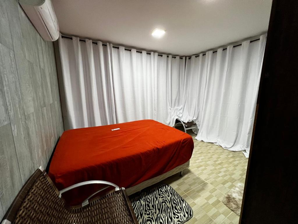 卡博迪圣阿戈斯蒂尼奥Casa de praia padrão enseadas dos corais的白色窗帘的房间的一张床位