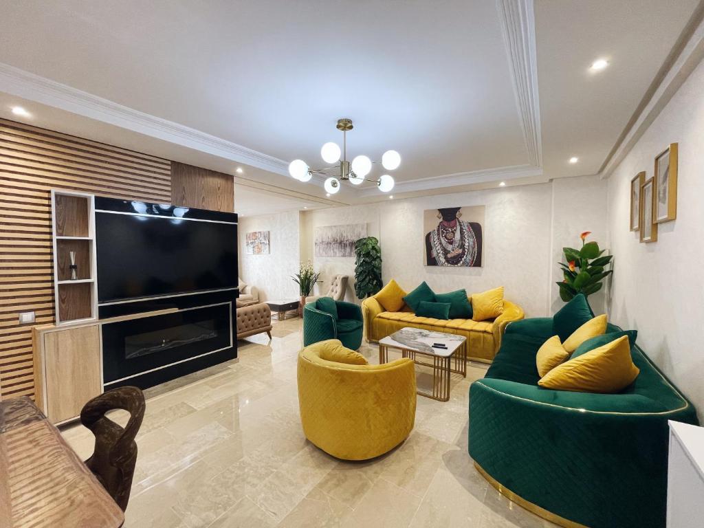 卡萨布兰卡High Standing & cozy apartment in central Casablanca的客厅配有绿色家具和平面电视