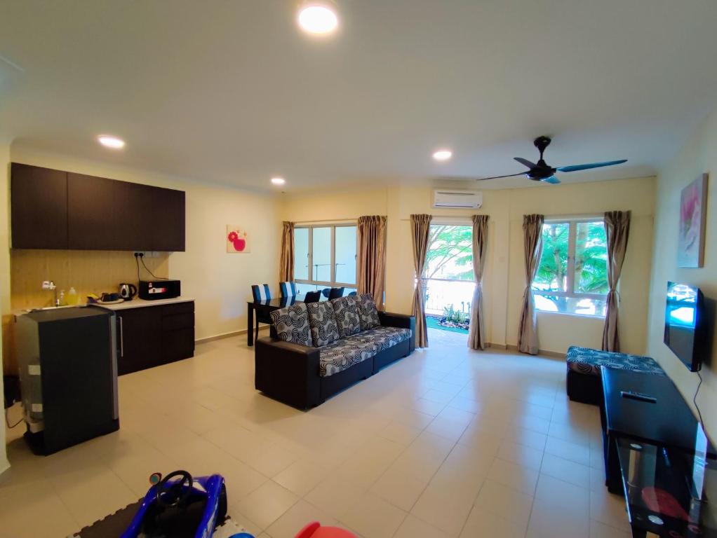 迪沙鲁Le'Coco Homestay in Tiara Desaru Residence的带沙发的客厅和厨房