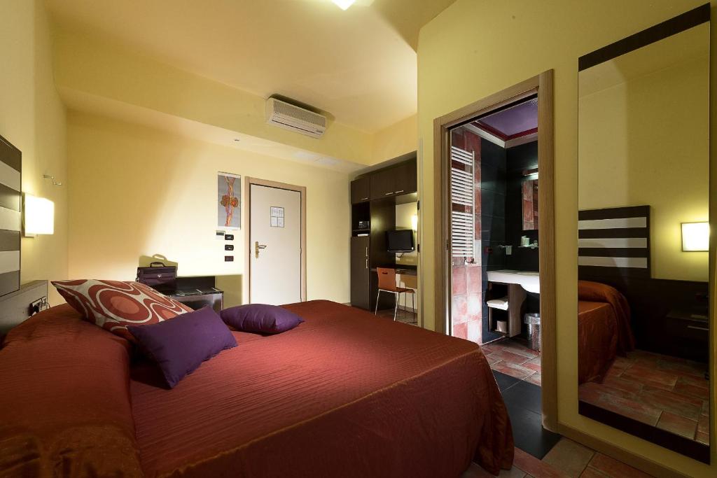博洛尼亚拉皮奥帕酒店的一间卧室配有一张大床和镜子