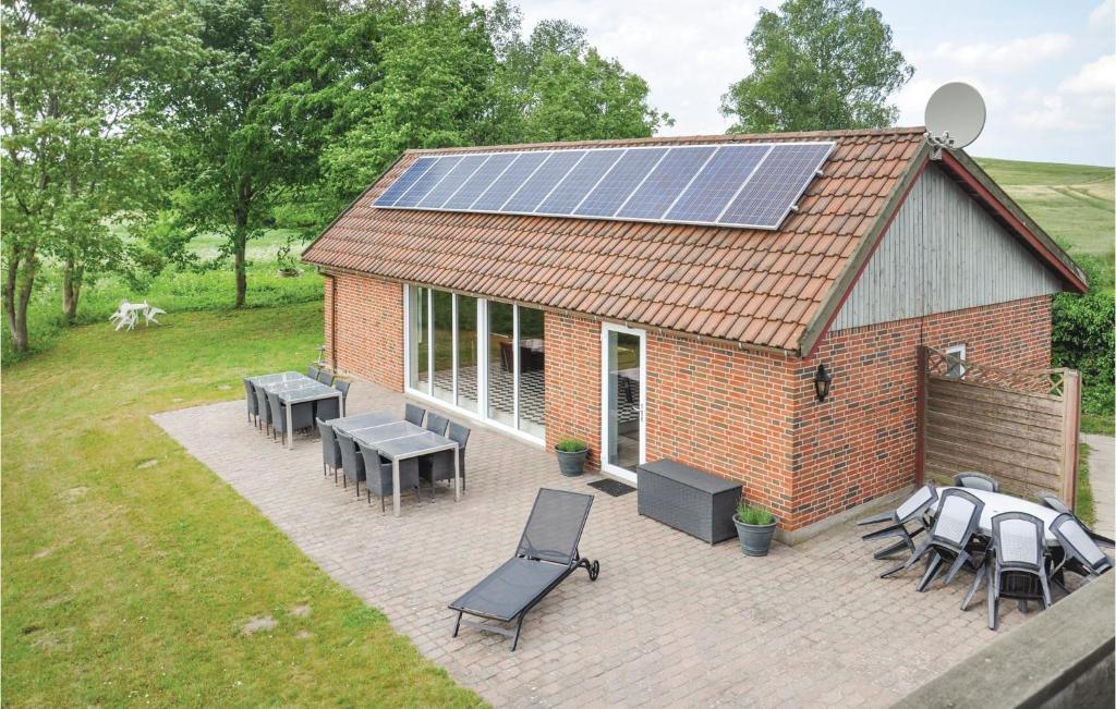 福堡Gorgeous Home In Faaborg With Sauna的房屋设有太阳能屋顶,配有桌椅