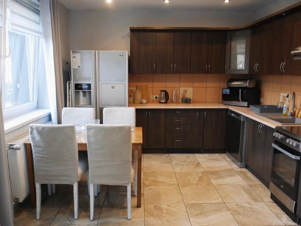 文盖尔斯卡－古尔卡Apartamenty Pod Hutą的厨房配有桌椅和冰箱。