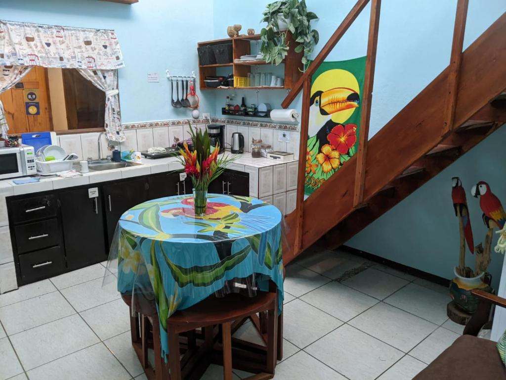 阿拉胡埃拉Guesthouse Casa Lapa2的厨房配有一张桌子,上面放着花瓶