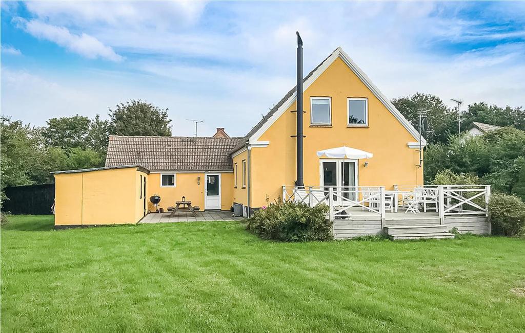ØstermarieCozy Home In stermarie With Kitchen的前面有大院子的黄色房子