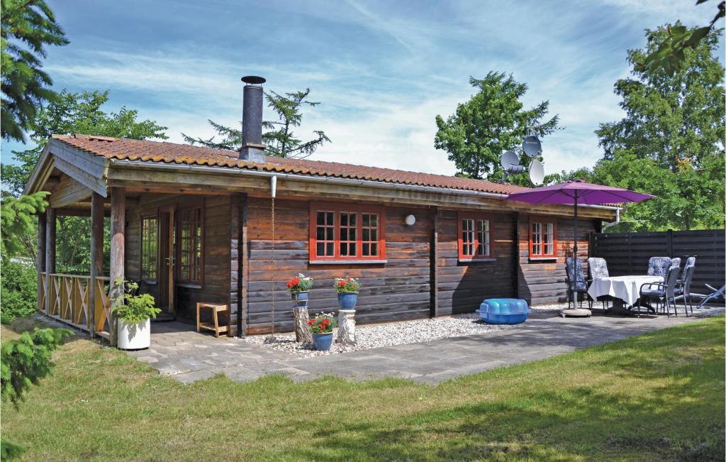 BakkegårdeNice Home In Jgerspris With Wifi的小屋设有天井和桌子。