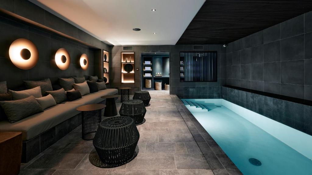 巴黎Le Bellune Paris的酒店大堂设有游泳池、沙发和桌子