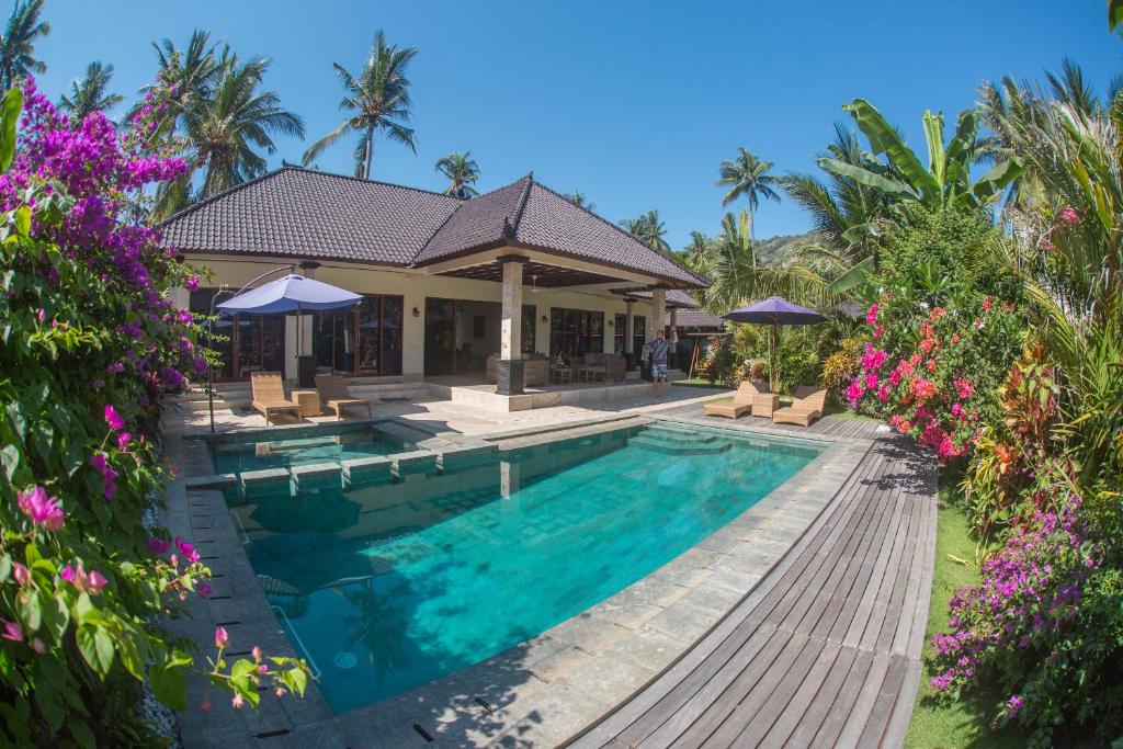 甘地达萨巴龙别墅的一座别墅,设有游泳池和棕榈树