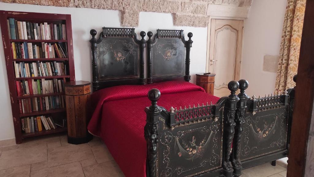 加拉蒂纳La Controra的一间卧室配有一张黑色床和红色毯子