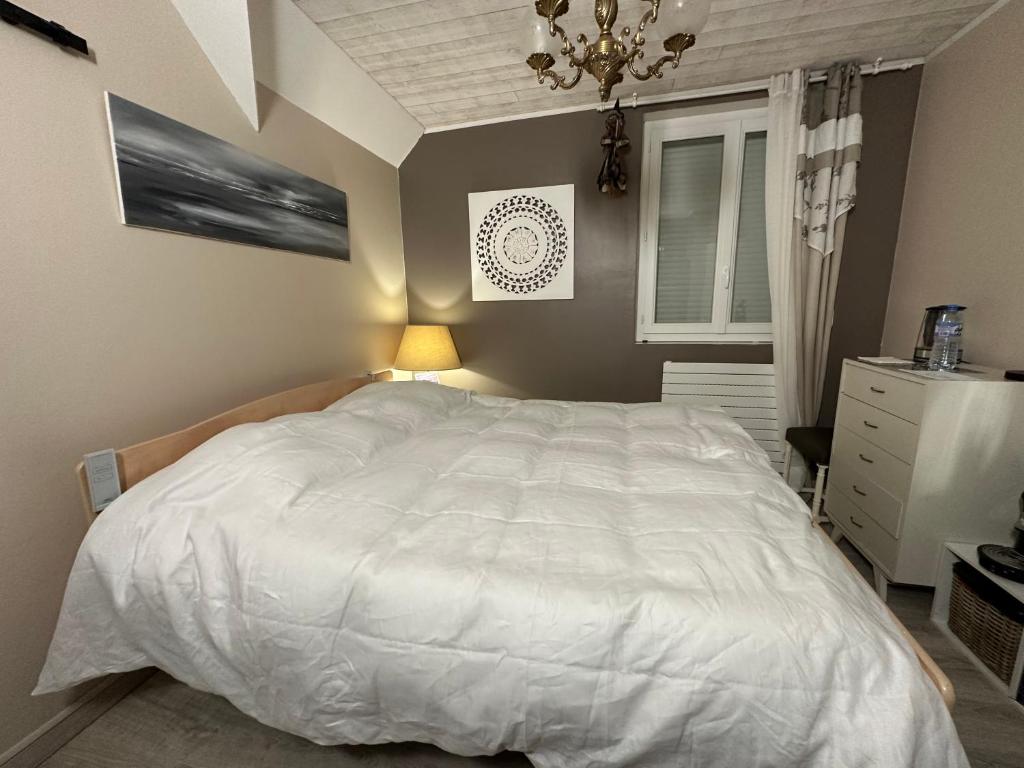 滨海贝尔克Villa les Buissonets的卧室配有一张白色大床和吊灯。