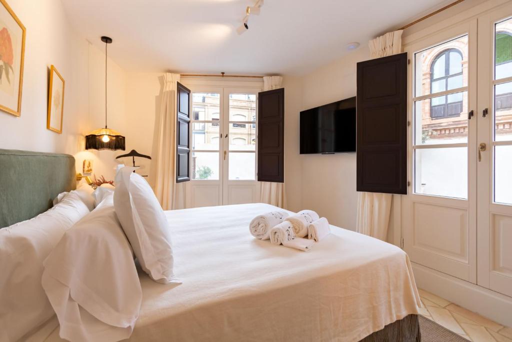 塞维利亚Casa de la Moneda Residences Sevilla的卧室里有一张白色的床，床上放着毛巾