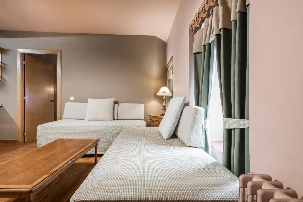 维耶拉Riu Nere Mountain Apartments的酒店客房设有两张床和一张桌子。