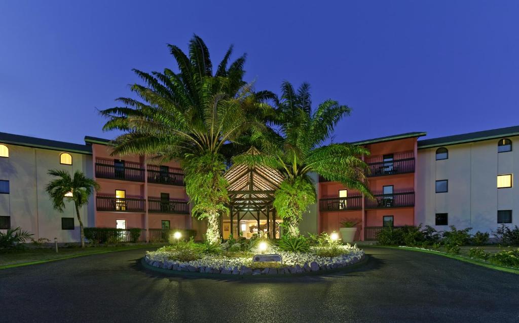 卡宴Grand Hotel Montabo的两棵棕榈树的建筑