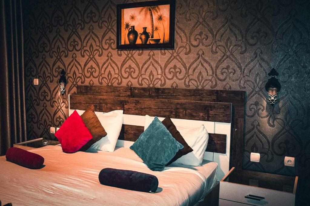 安曼拜尔克尼酒店的一间卧室配有一张带色彩缤纷枕头的大床