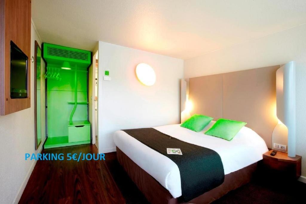 雷恩西雷恩克劳内钟楼酒店的酒店客房配有一张带绿色枕头的大床