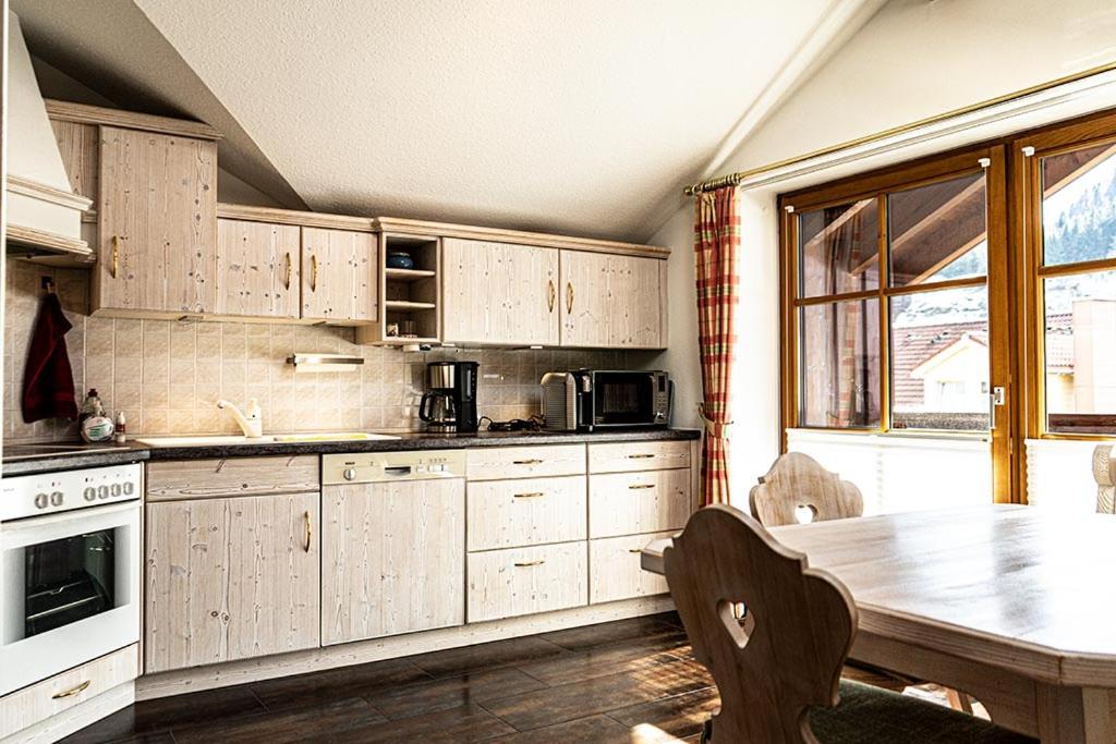 上施陶芬Seelenruhe的厨房配有木制橱柜和桌椅