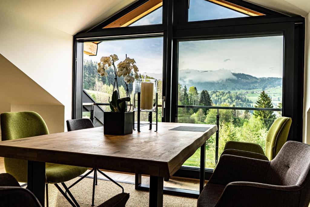 上施陶芬Alpenloft Ausblick的一间带桌子和大窗户的用餐室