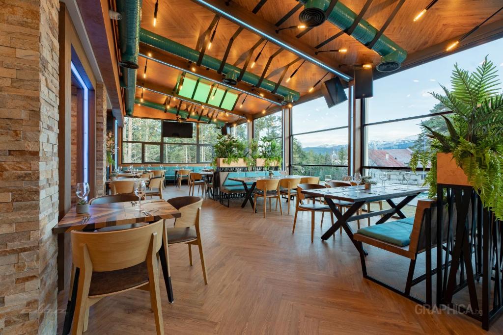 潘尼希特103 View Park Hotel & SPA的餐厅设有桌椅和大窗户。