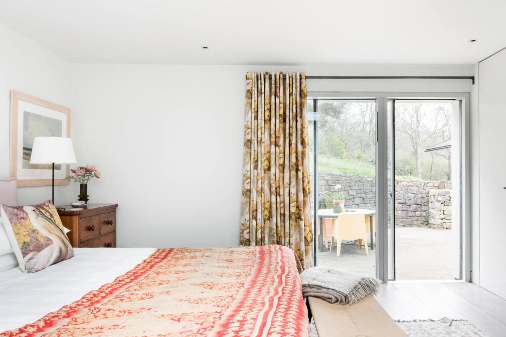 温彻斯特The Oaks, Twyford Moors, South Downs National Park的一间卧室设有一张床和一个滑动玻璃门