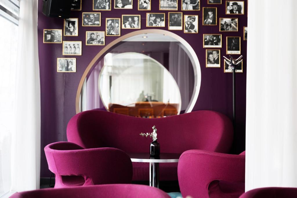 于默奥ProfilHotels Aveny的一间设有紫色椅子和镜子的客房
