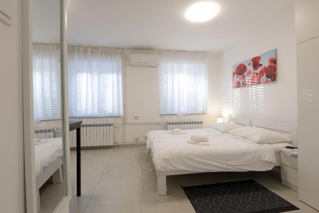 里耶卡Rijeka Budget Rooms的白色卧室配有床和镜子