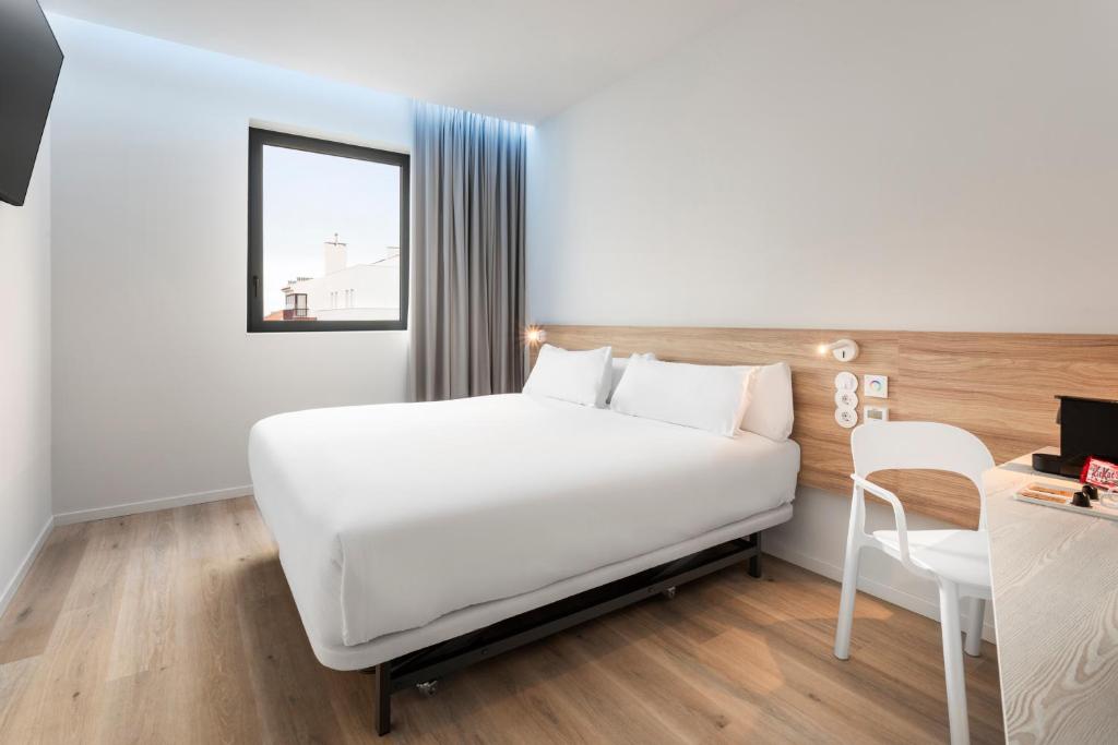 奥埃拉斯B&B HOTEL Lisboa Oeiras的卧室配有白色的床和书桌
