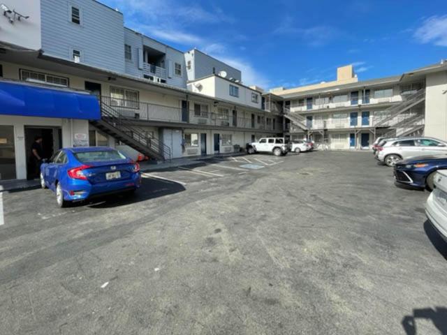 旧金山Motel 6 San Francisco CA Lombard Street的停车场,停车场停在大楼前
