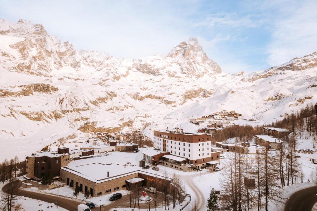 布勒伊-切尔维尼亚Valtur Cristallo Ski Resort, Dependance Cristallino的一座雪地中的建筑,背景是一座山