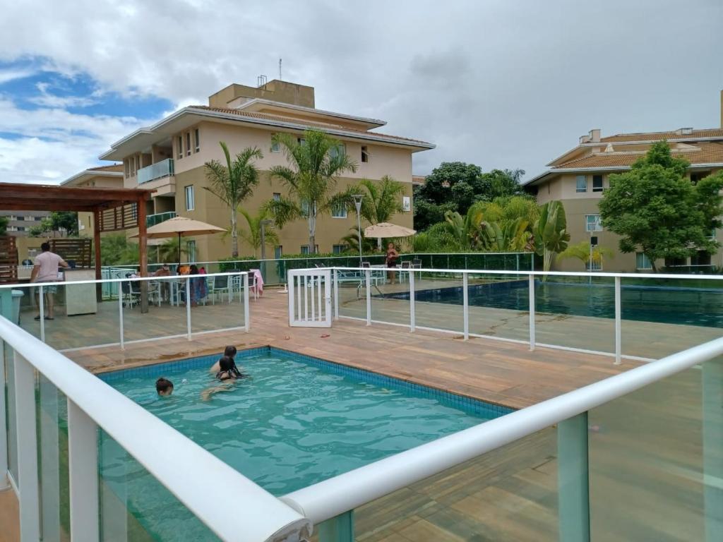 巴西利亚Lindo Flat em resort silencioso e aconchegante的几个人在度假村的游泳池里