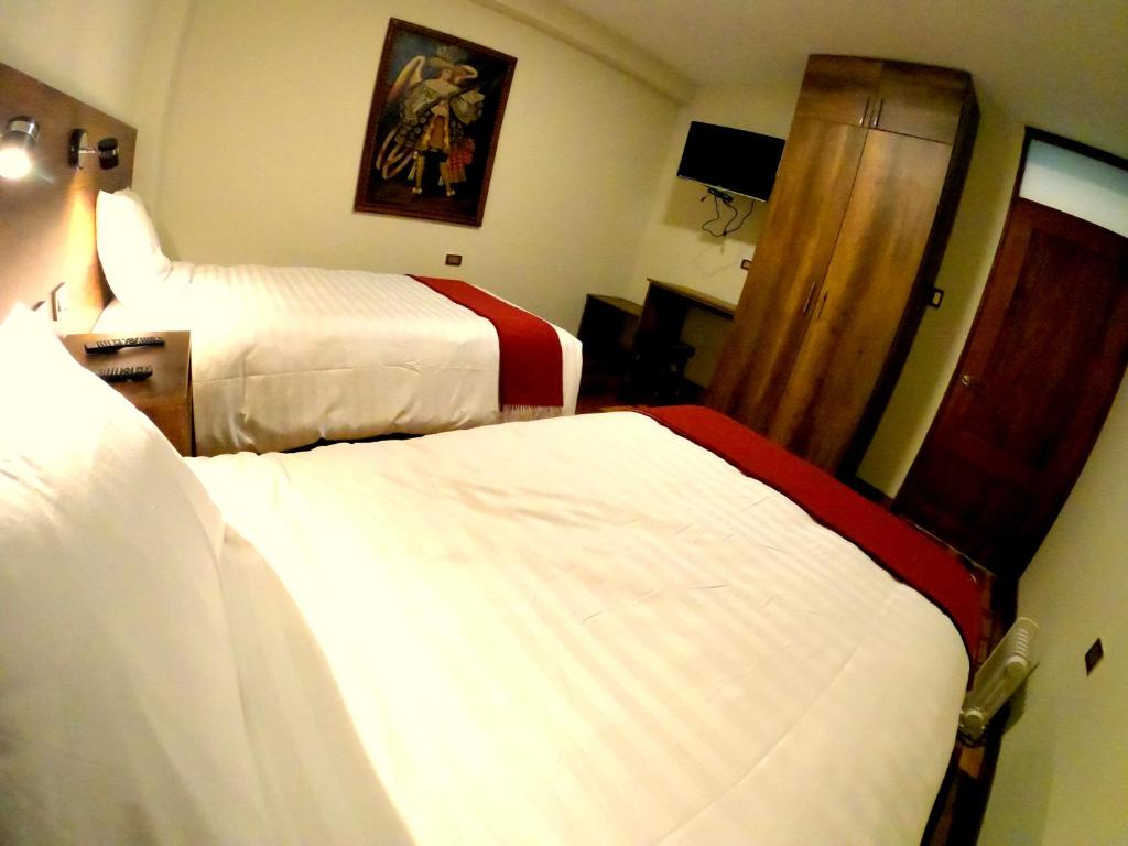 库斯科Zans Apartments Cusco的酒店客房,设有两张床和镜子
