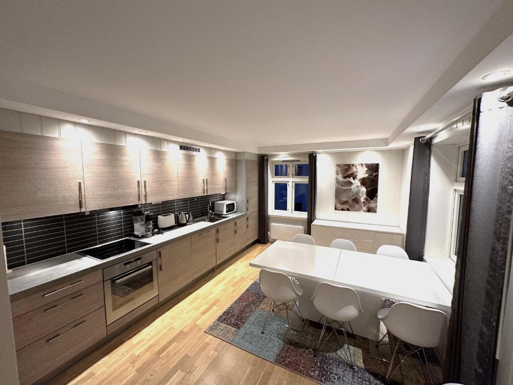 纳尔维克Stetind - Modern apartment with free parking的一个带白色大桌子和椅子的大厨房