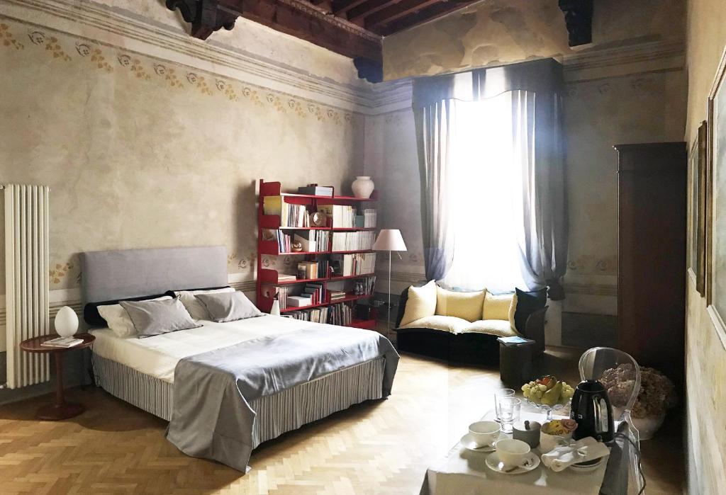 比萨Domus '400的一间卧室配有一张床、一张沙发和一张桌子